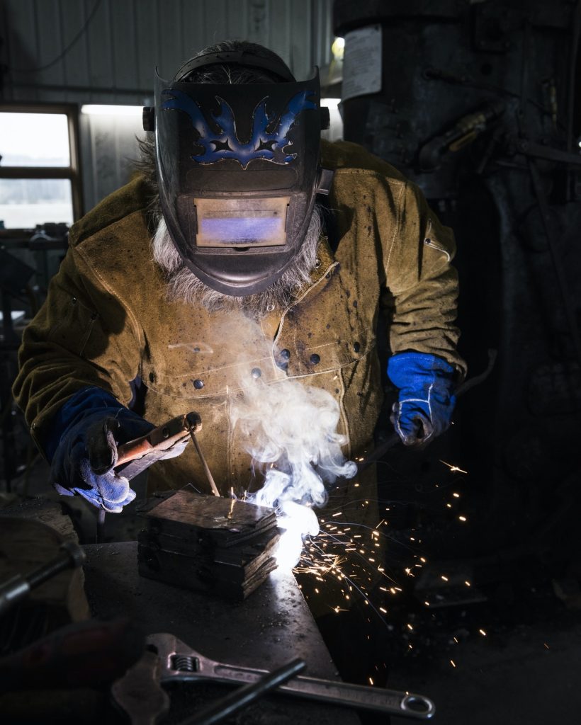 blacksmith-in-welding-mask-welding-metal-in-workshop.jpg blacksmith-in-welding-mask-welding-metal-in-workshop.jpg